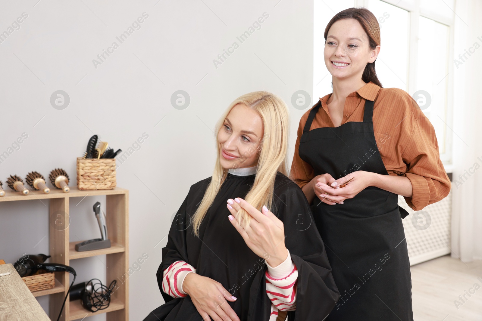 Photo of Hair cutting. Professional hairdresser working with client in salon