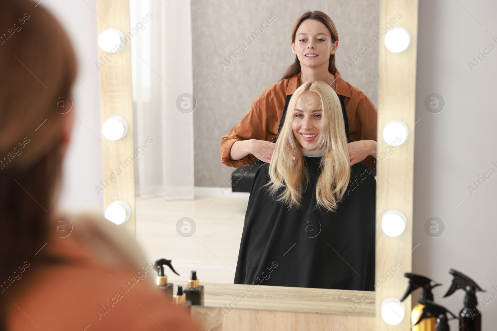 Photo of Hair cutting. Professional hairdresser working with client in salon, selective focus