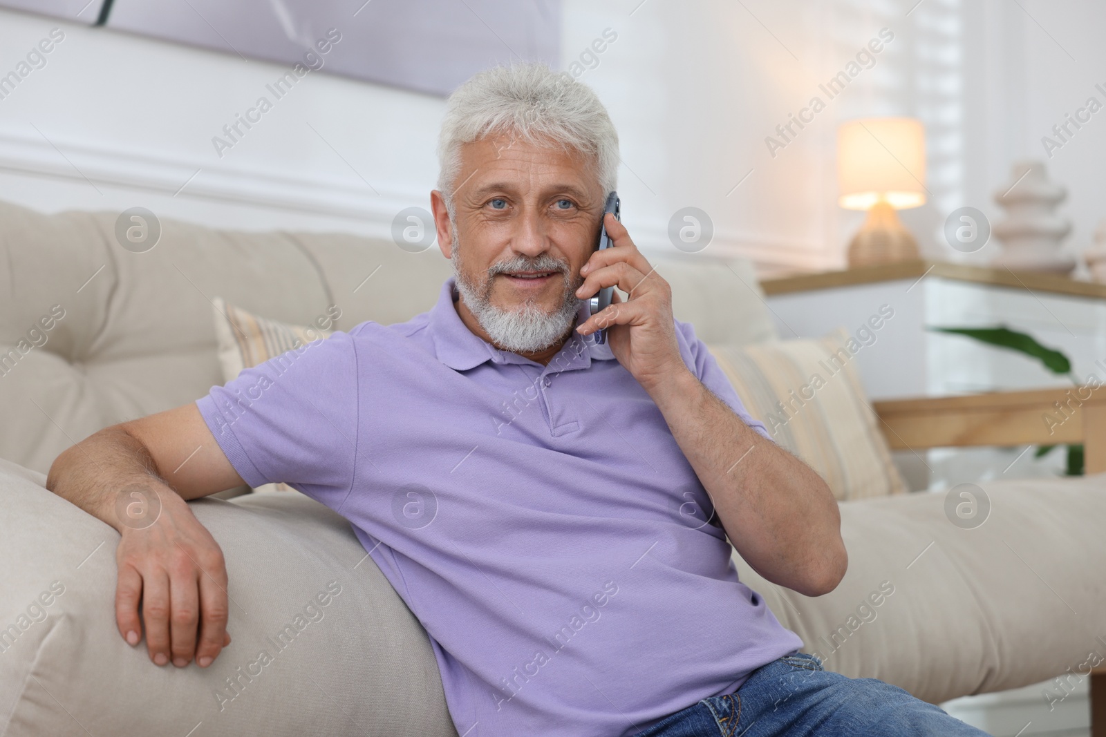 Photo of Senior man talking on phone at home