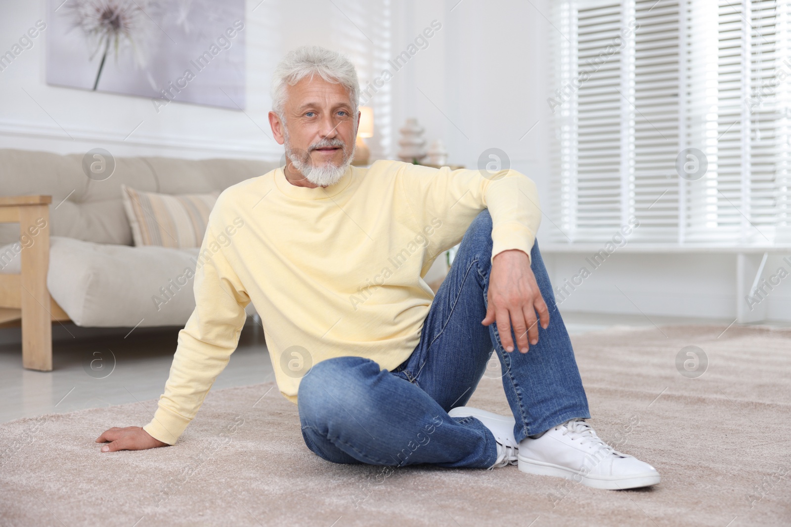 Photo of Senior man sitting on floor at home