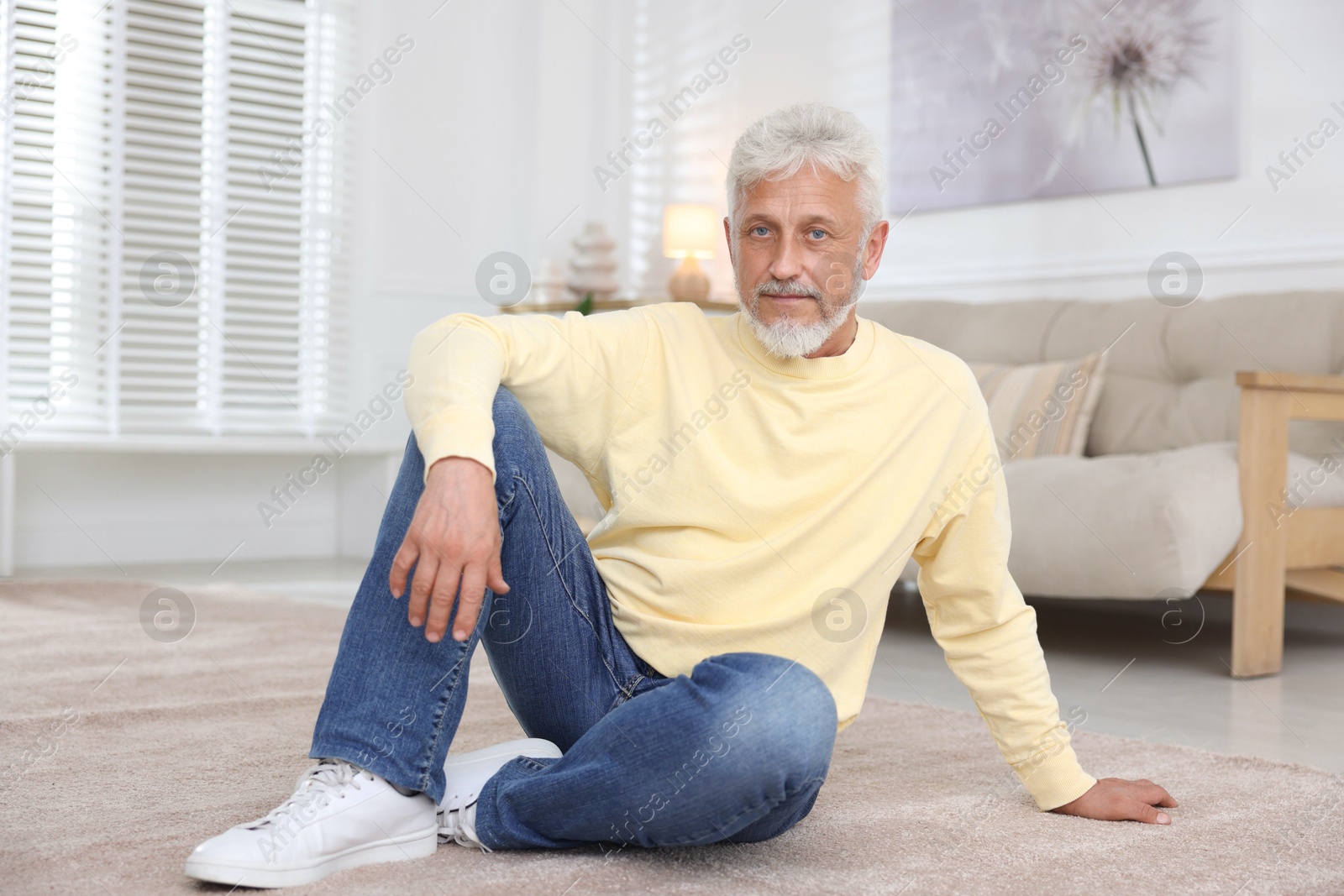 Photo of Senior man sitting on floor at home