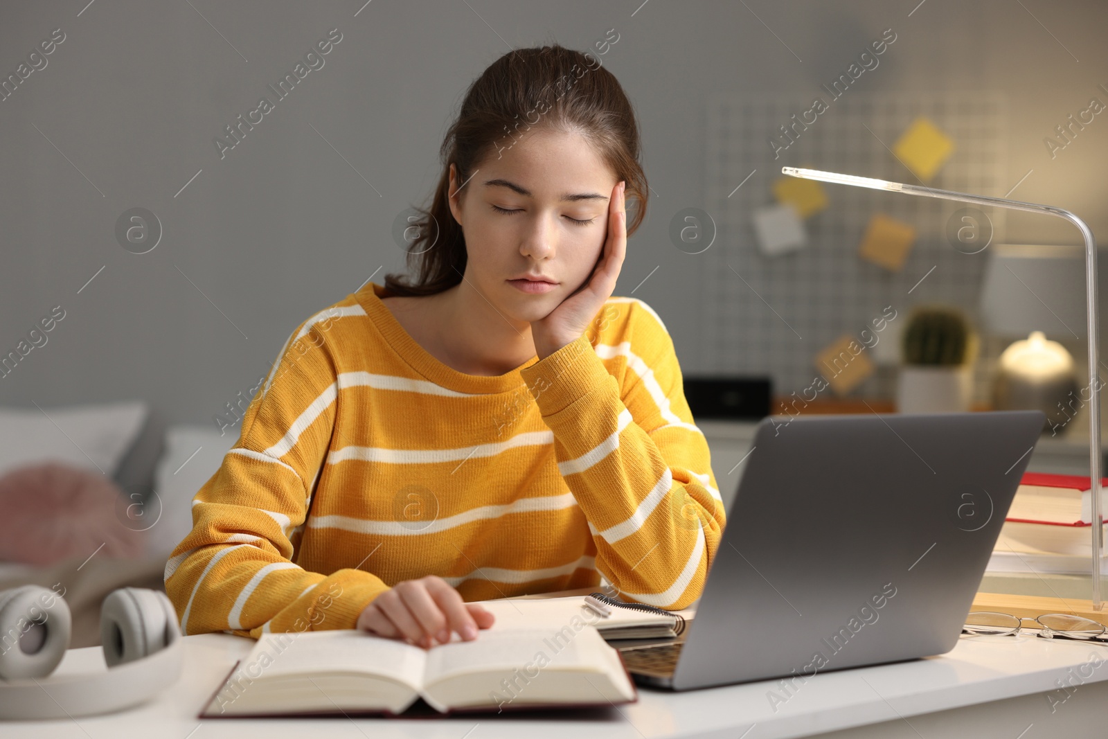 Photo of Preparing for exam. Tired student sleeping at table indoors