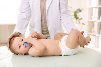 Photo of Pediatrician with little child in clinic, closeup. Checking baby's health