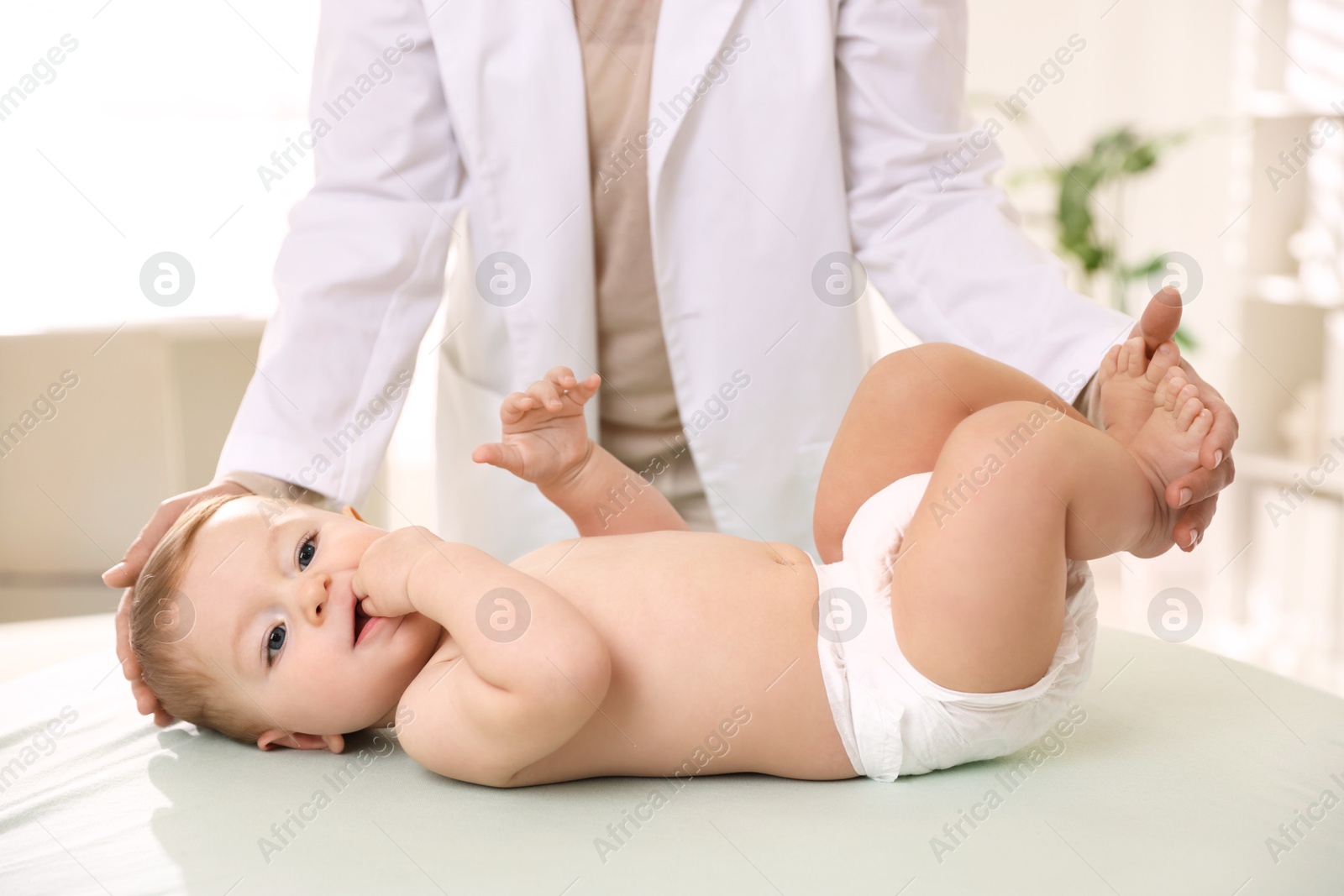 Photo of Pediatrician with little child in clinic, closeup. Checking baby's health