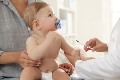 Photo of Pediatrician vaccinating little baby in clinic, closeup