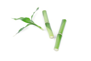 Photo of Pieces of decorative bamboo plant and green leaves isolated on white