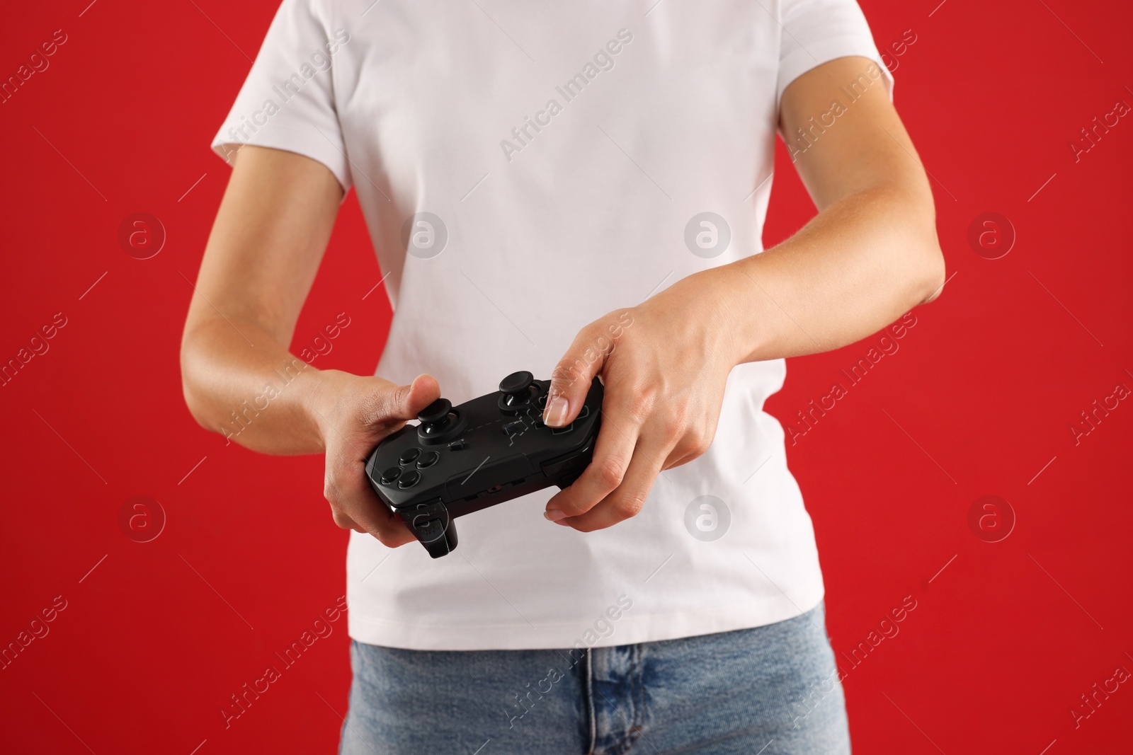 Photo of Woman with controller on red background, closeup