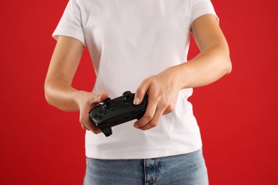 Photo of Woman with controller on red background, closeup