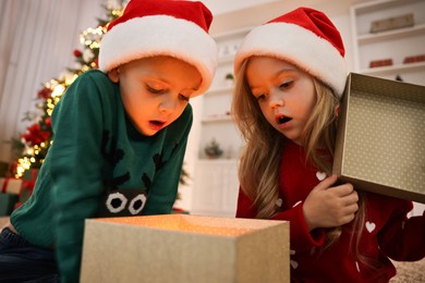 Photo of Little kids opening magic Christmas box at home