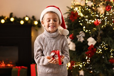 Photo of Little boy with Christmas ornament at home