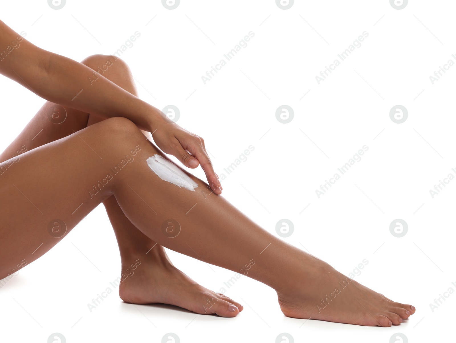 Photo of Woman applying cream onto leg on white background, closeup