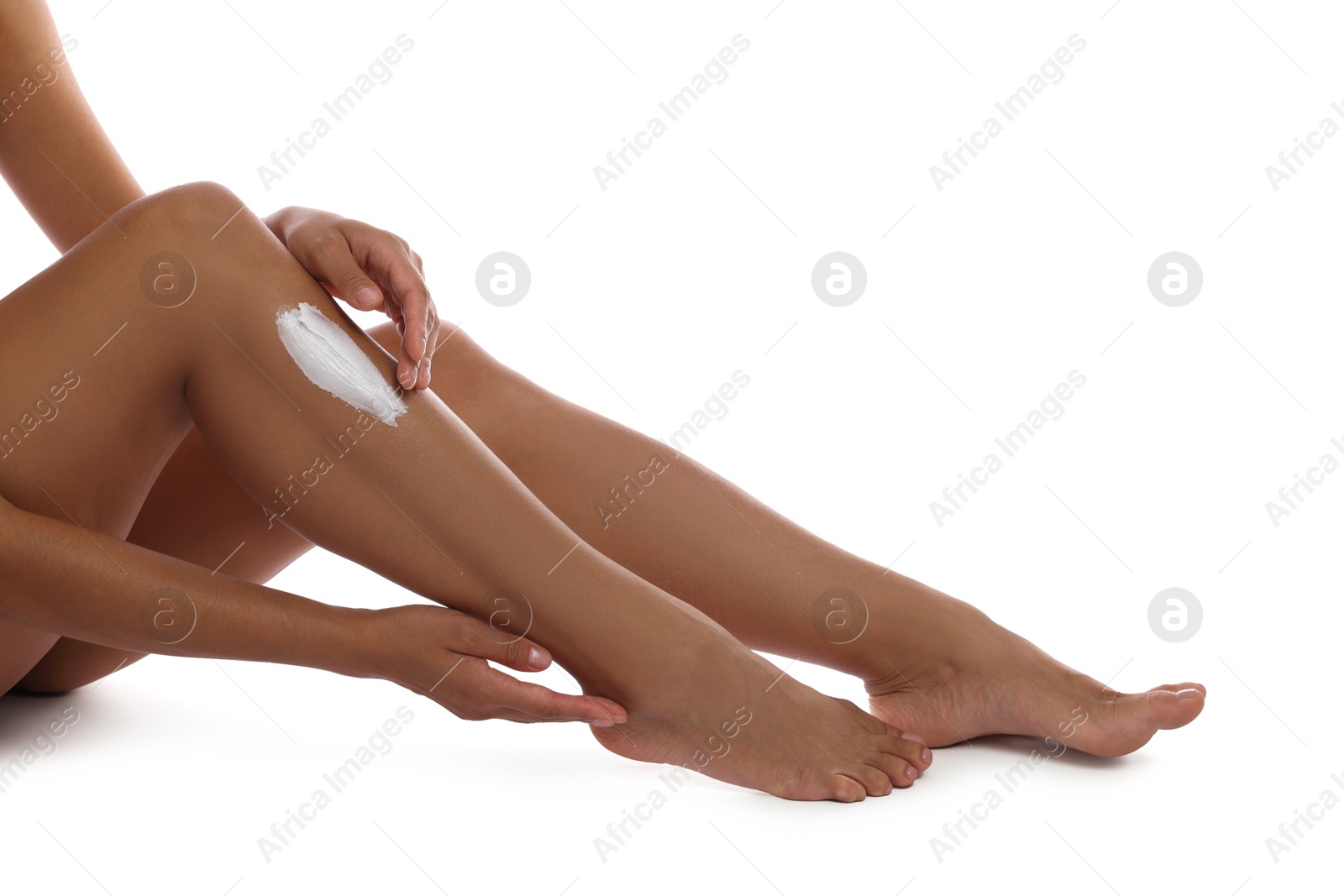 Photo of Woman applying cream onto leg on white background, closeup