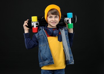 Photo of Little boy with skateboard on black background