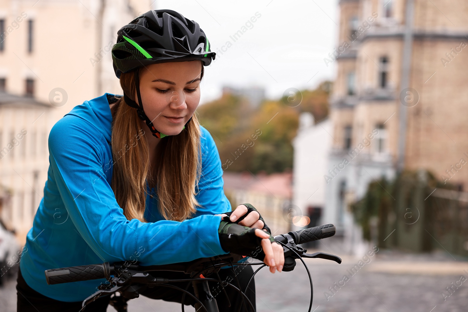 Photo of Woman with helmet and bicycle outdoors, space for text