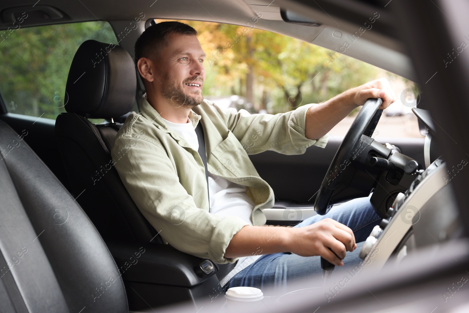 Photo of Man driving modern car, view through window