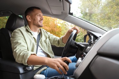 Photo of Happy man behind steering wheel of modern car