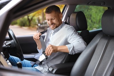 Photo of Man fastening seat belt in modern car