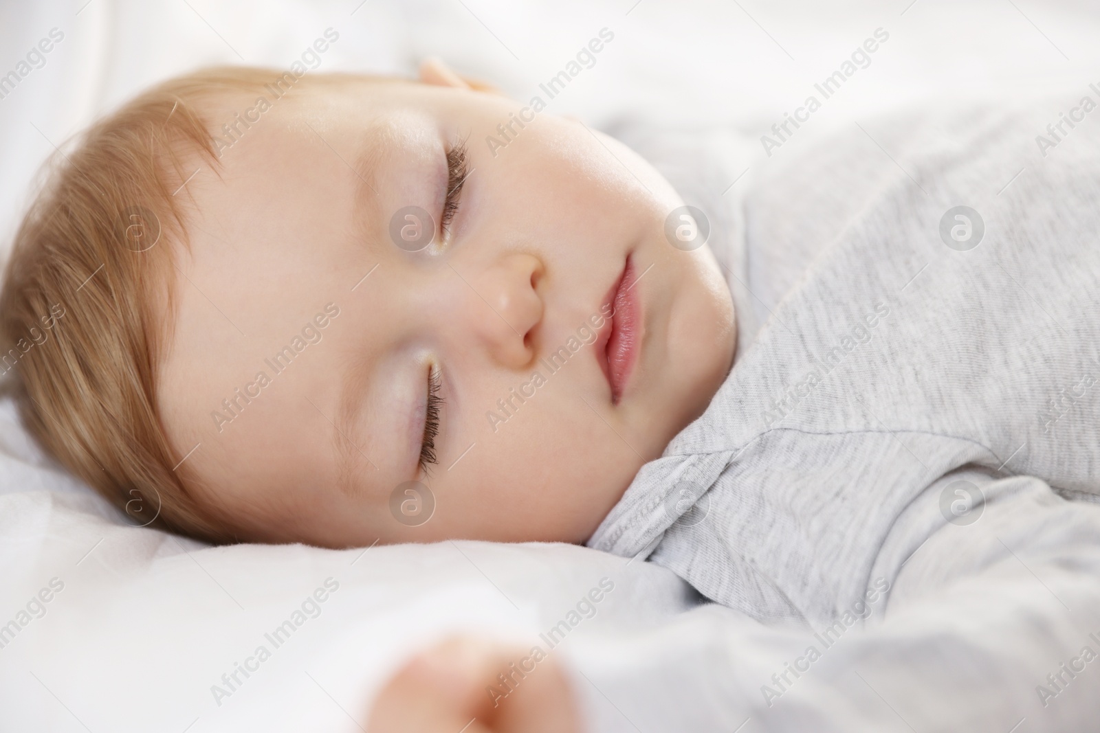 Photo of Cute little baby sleeping on bed at home, closeup