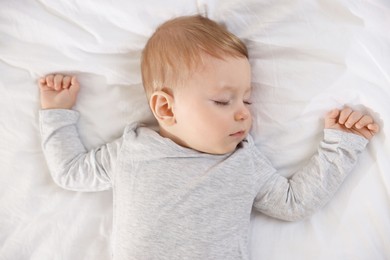 Photo of Cute little baby sleeping on bed at home, top view