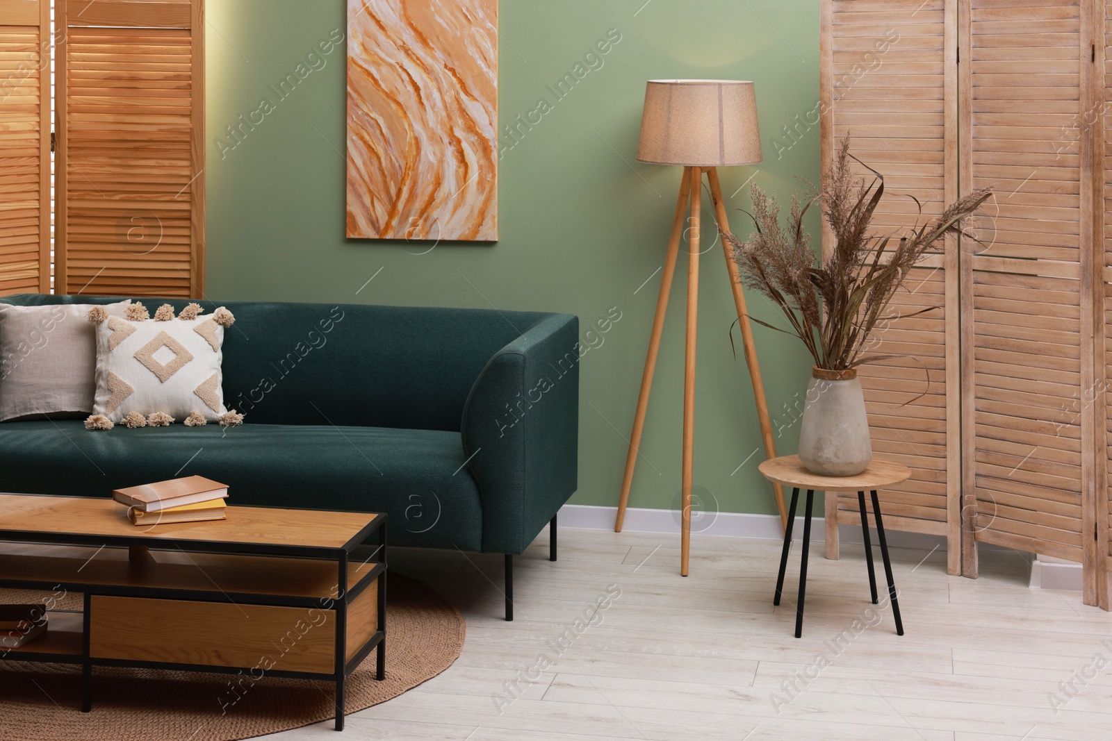 Photo of Soft sofa and other furniture near green wall in stylish living room