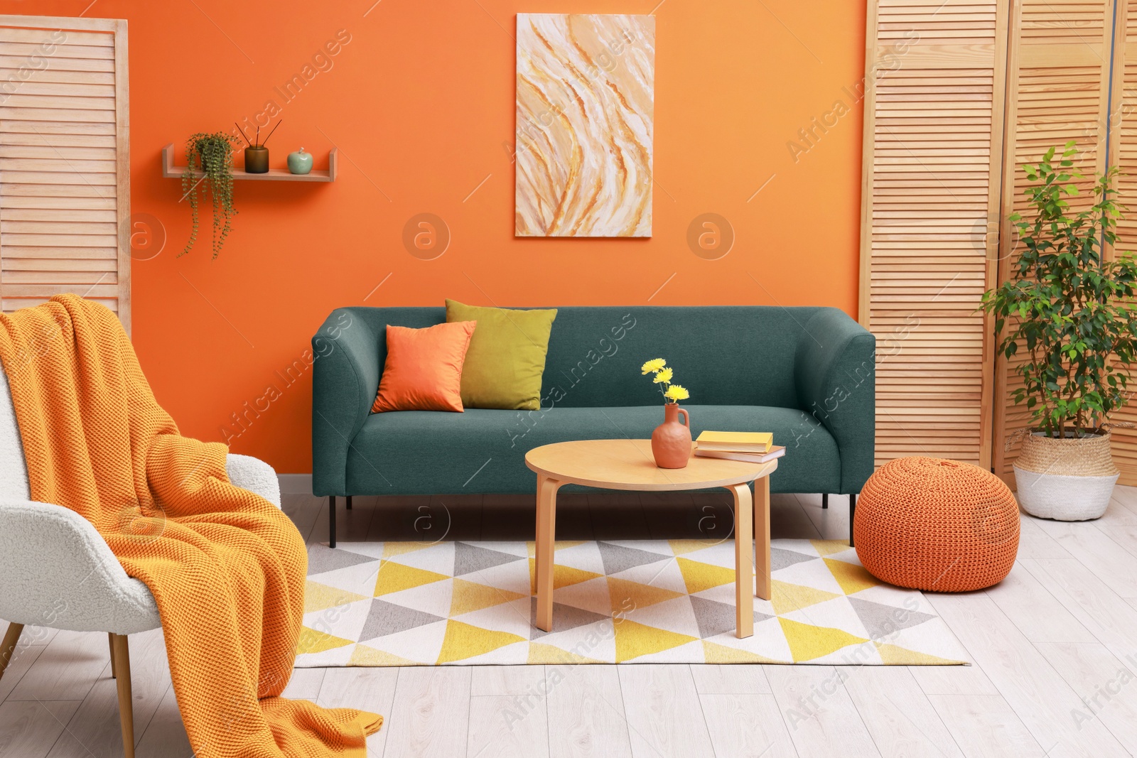 Photo of Stylish living room interior with comfortable sofa near orange wall