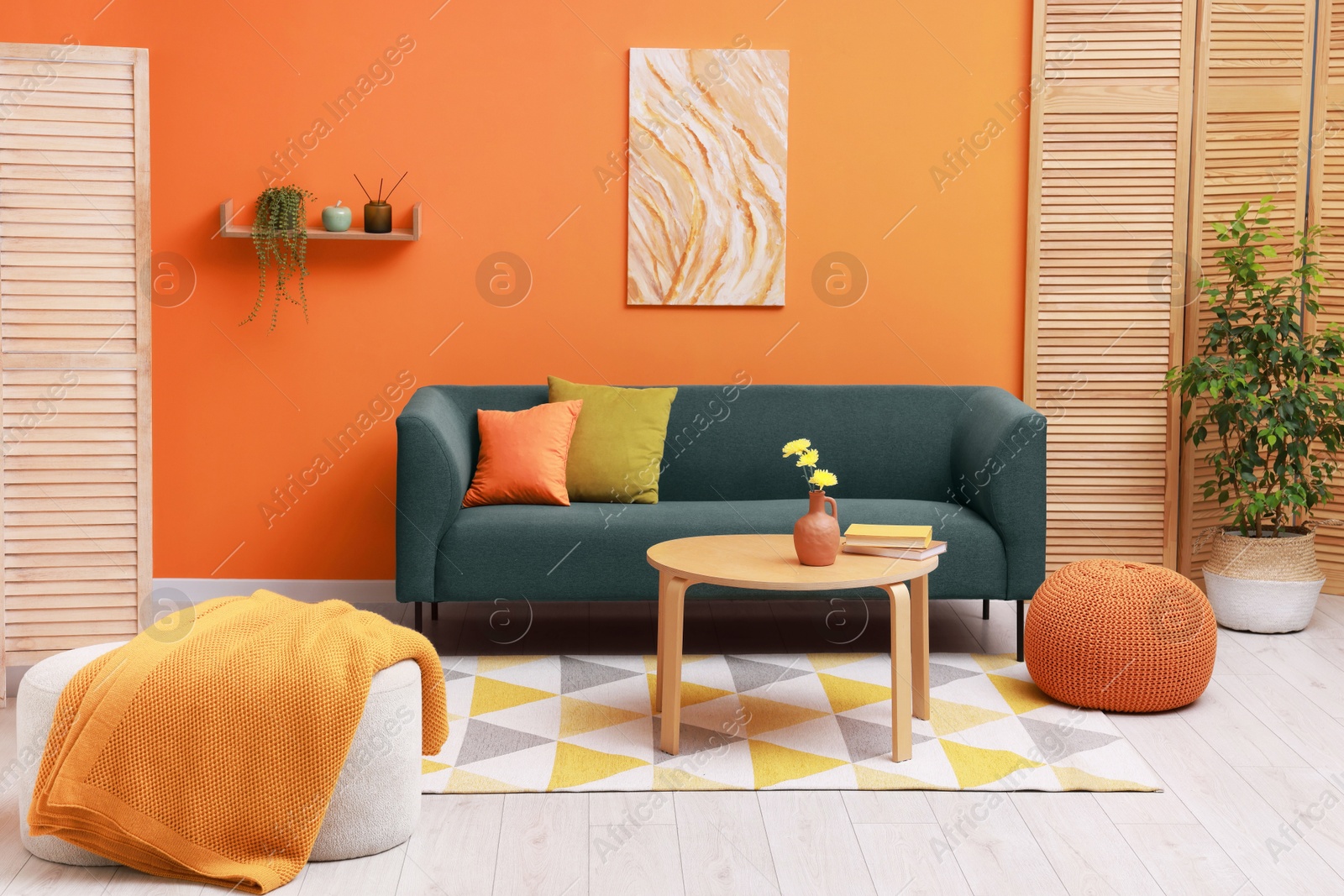 Photo of Stylish living room interior with comfortable sofa near orange wall