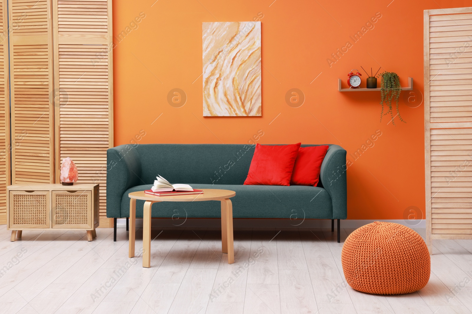 Photo of Stylish living room interior with comfortable sofa near orange wall