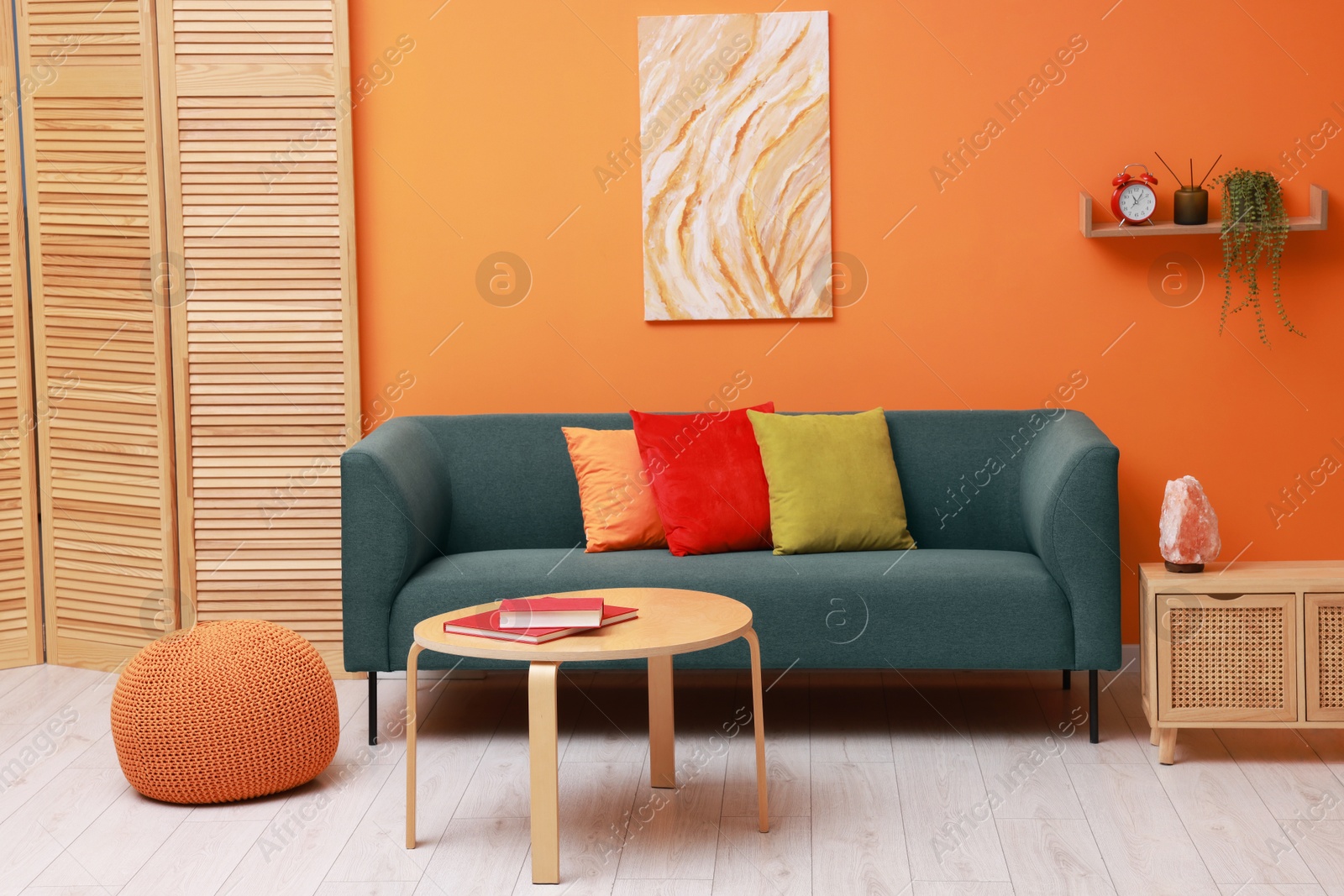 Photo of Stylish living room interior with comfortable sofa near orange wall