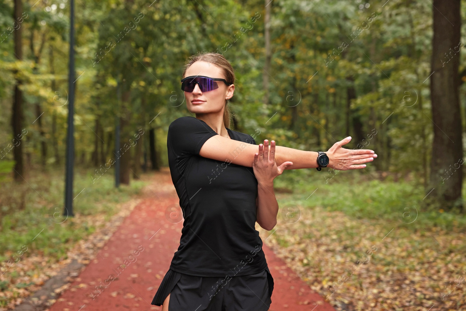 Photo of Young athletic woman stretching in park. Healthy lifestyle