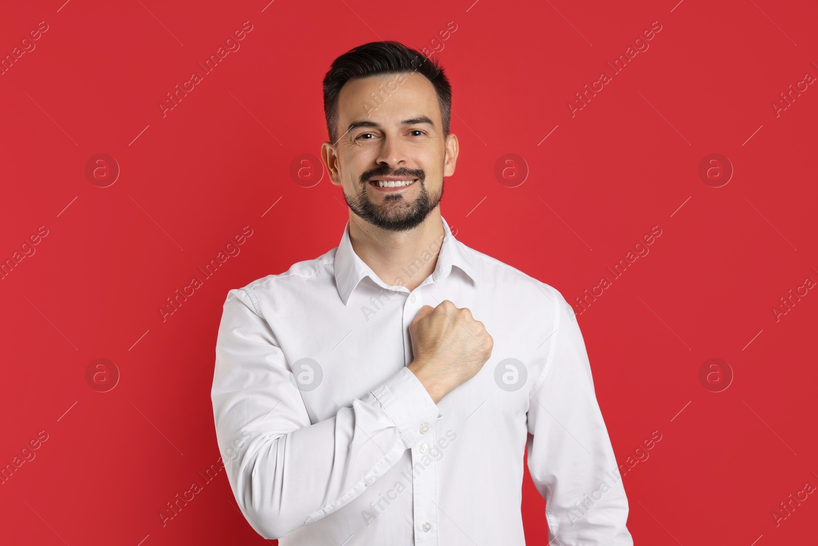 Photo of Man making promise on red background. Oath gesture