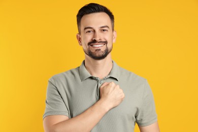 Photo of Man making promise on orange background. Oath gesture