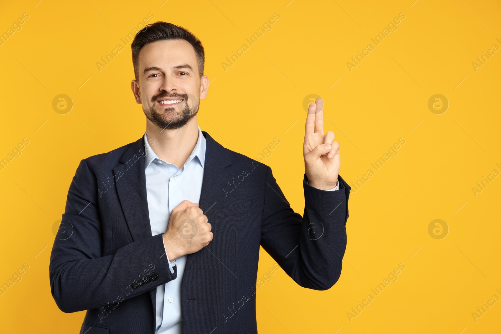 Photo of Man showing oath gesture on orange background, space for text. Making promise