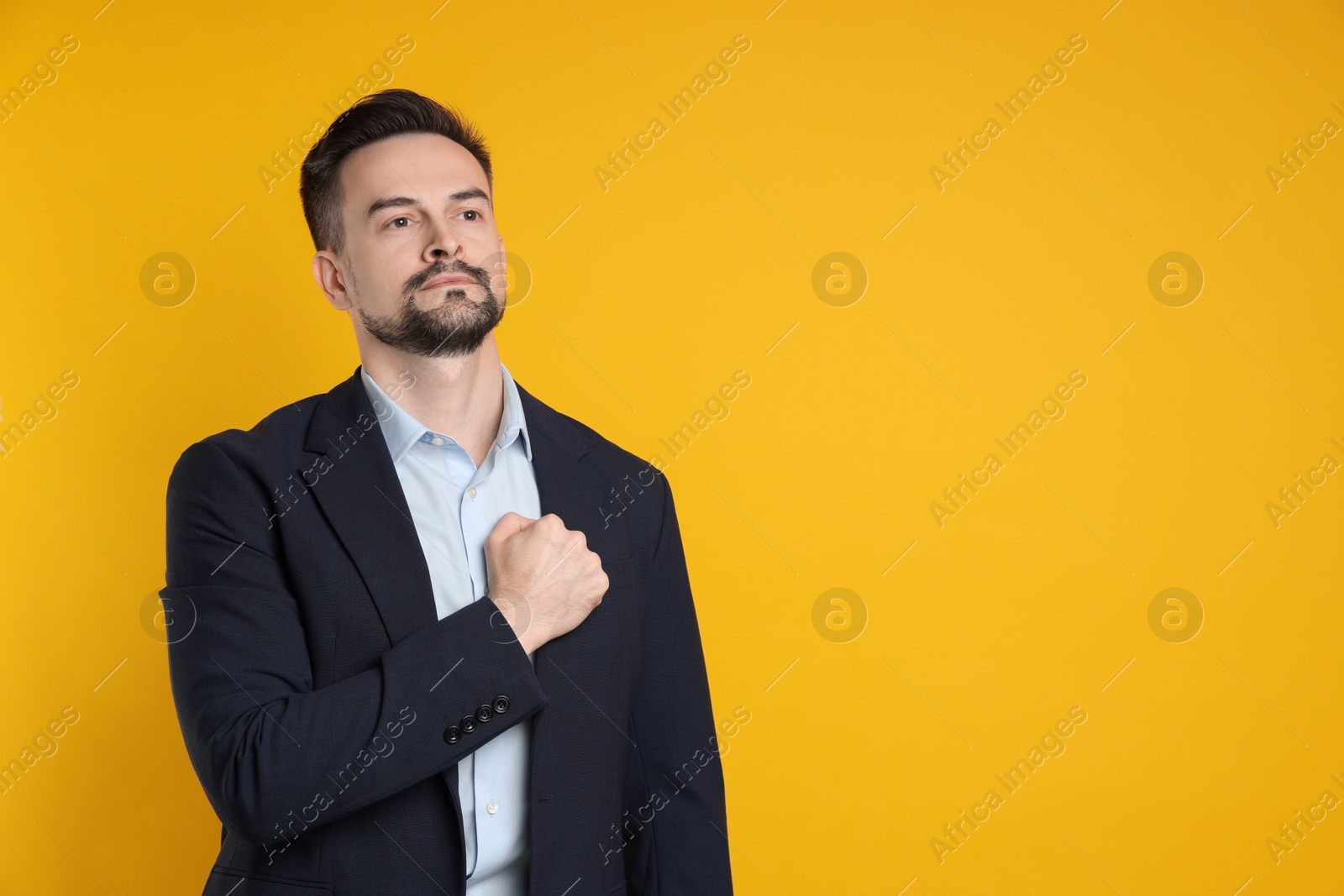 Photo of Man making promise on orange background, space for text. Oath gesture