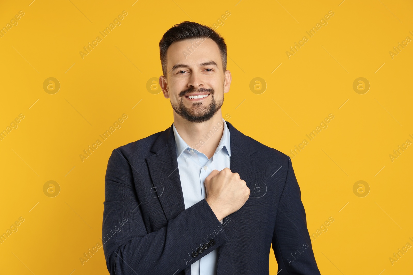 Photo of Man making promise on orange background. Oath gesture