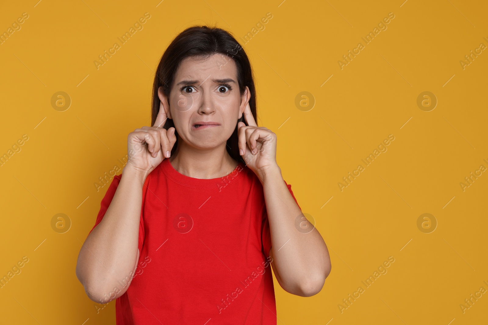 Photo of Woman showing hand to ear gesture on orange background, space for text