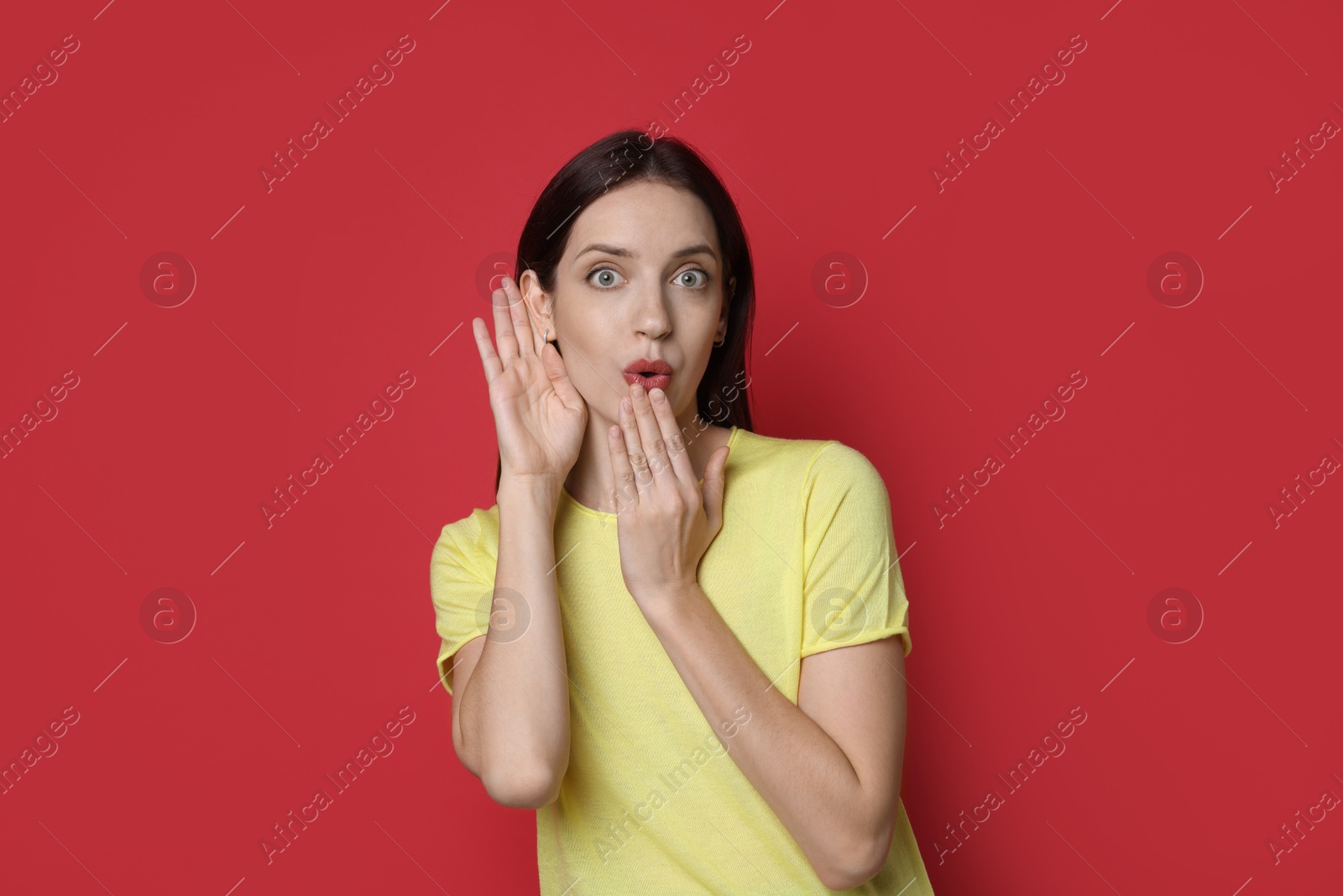 Photo of Woman showing hand to ear gesture on red background