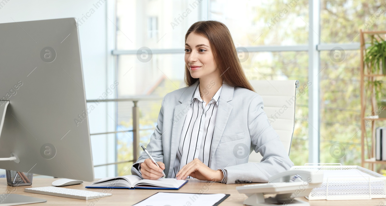 Photo of Banker taking notes at table in office