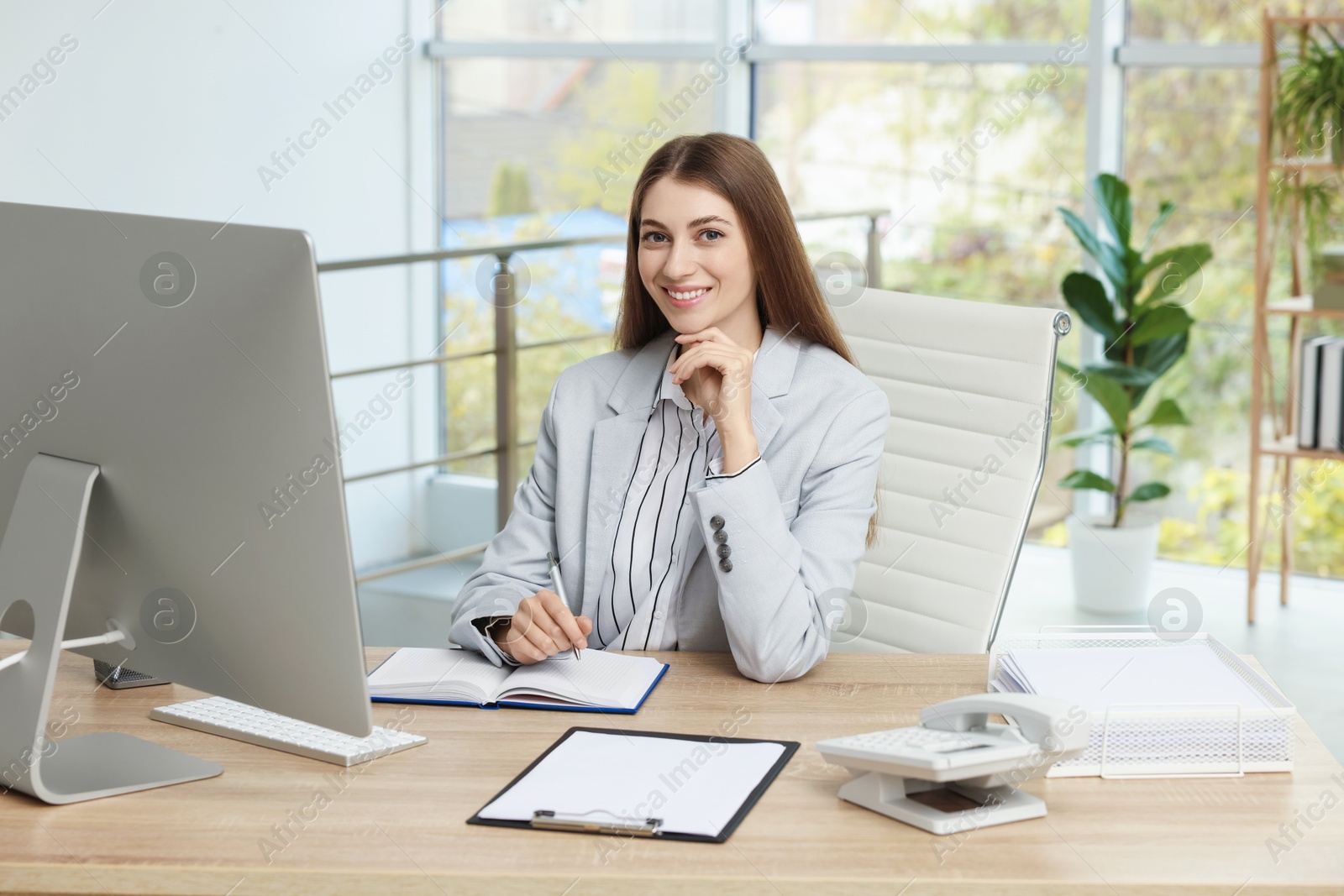 Photo of Banker taking notes at table in office