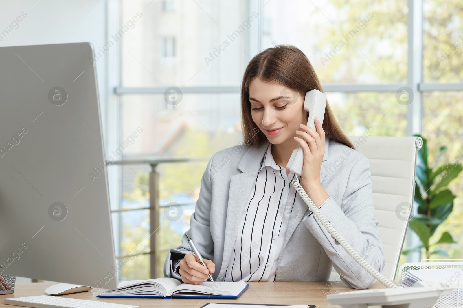 Photo of Banker talking on telephone at table in office