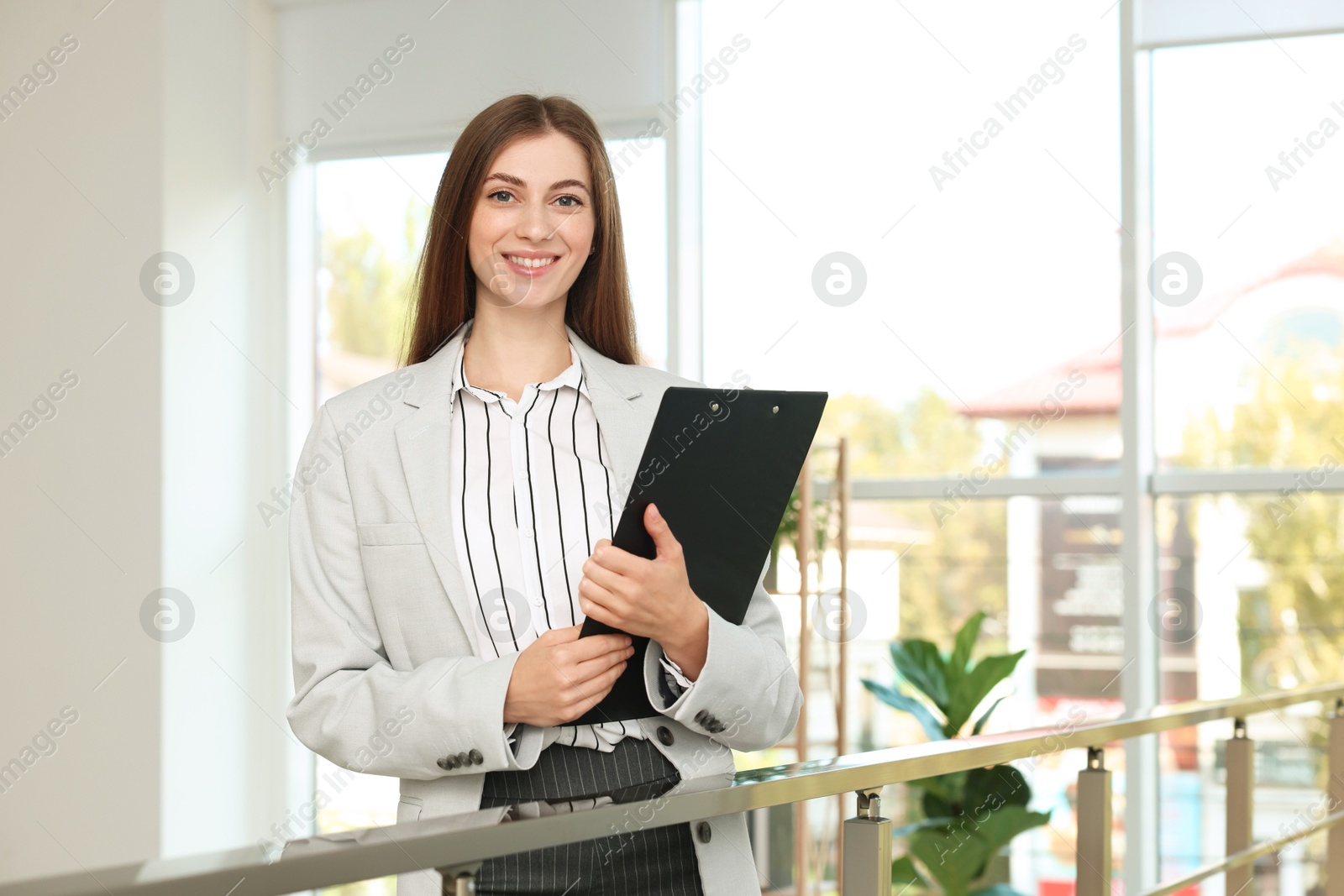 Photo of Portrait of banker with clipboard in office. Space for text