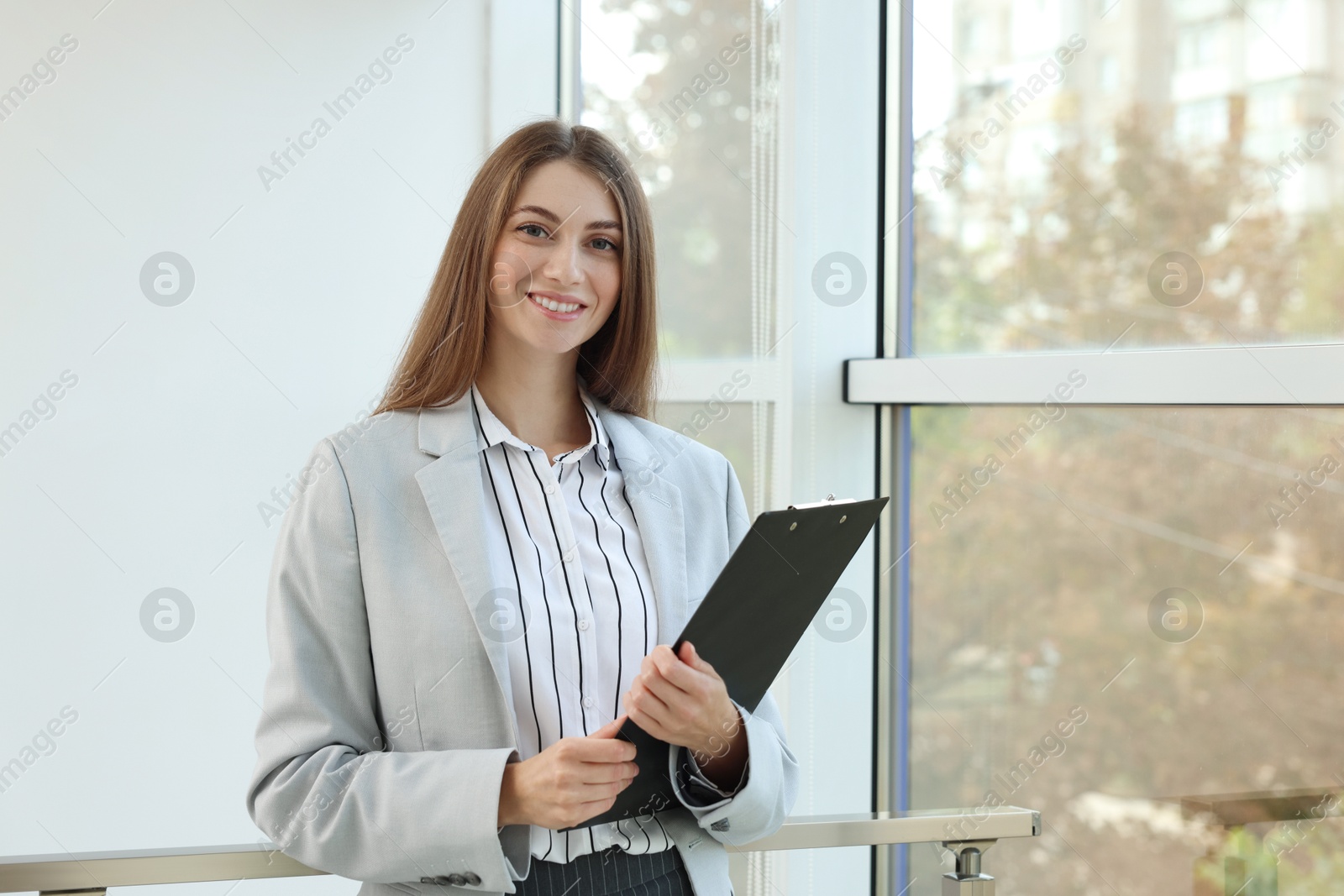 Photo of Portrait of banker with clipboard in office. Space for text