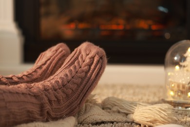 Photo of Woman in knitted socks resting at home, closeup