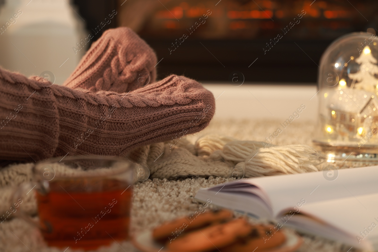 Photo of Woman in knitted socks resting at home, closeup