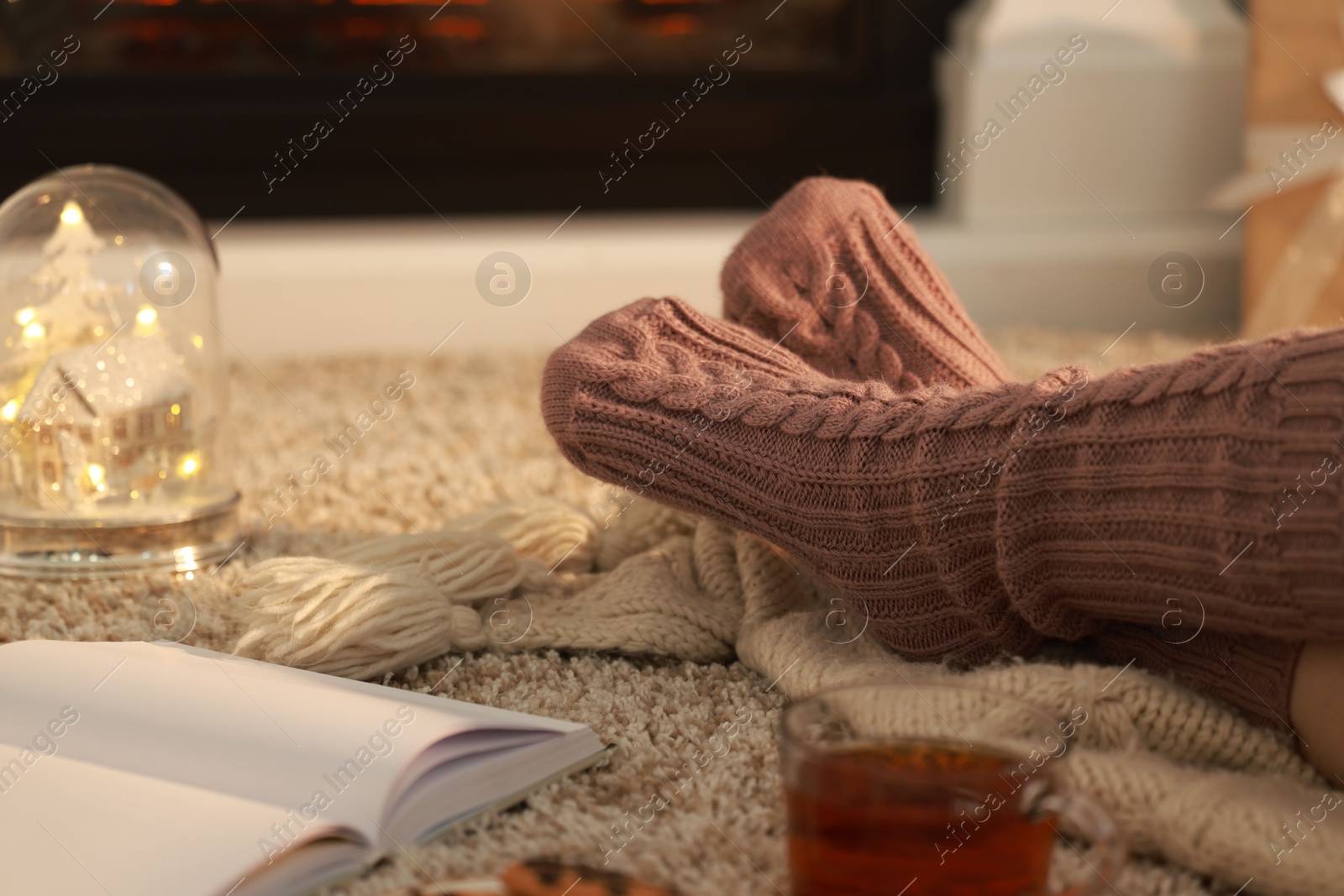 Photo of Woman in knitted socks resting at home, closeup