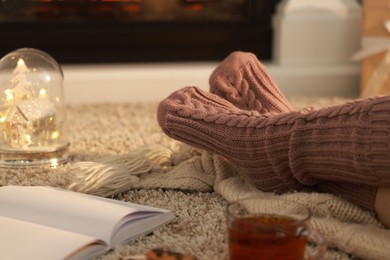 Photo of Woman in knitted socks resting at home, closeup