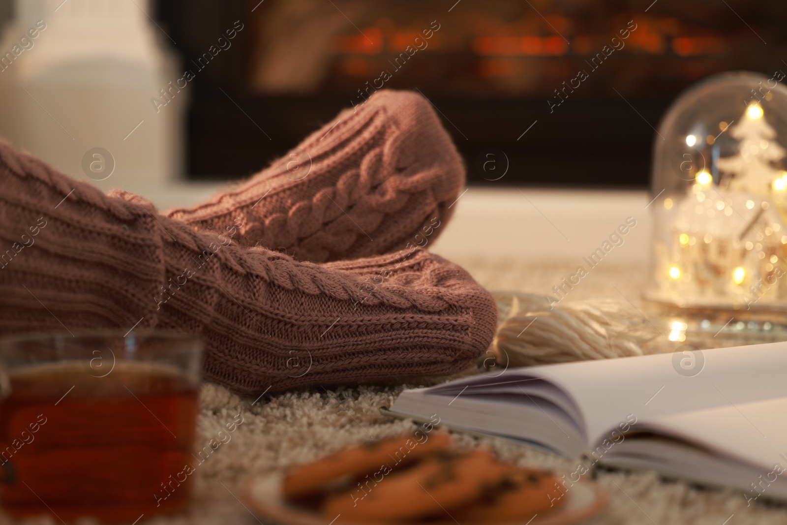 Photo of Woman in knitted socks resting at home, closeup