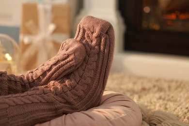 Woman in knitted socks resting at home, closeup. Space for text