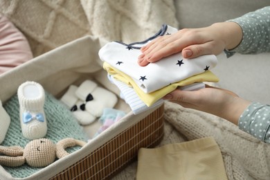 Photo of Woman with baby clothes at home, closeup