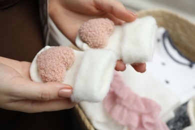 Photo of Pregnant woman with baby socks at home, closeup