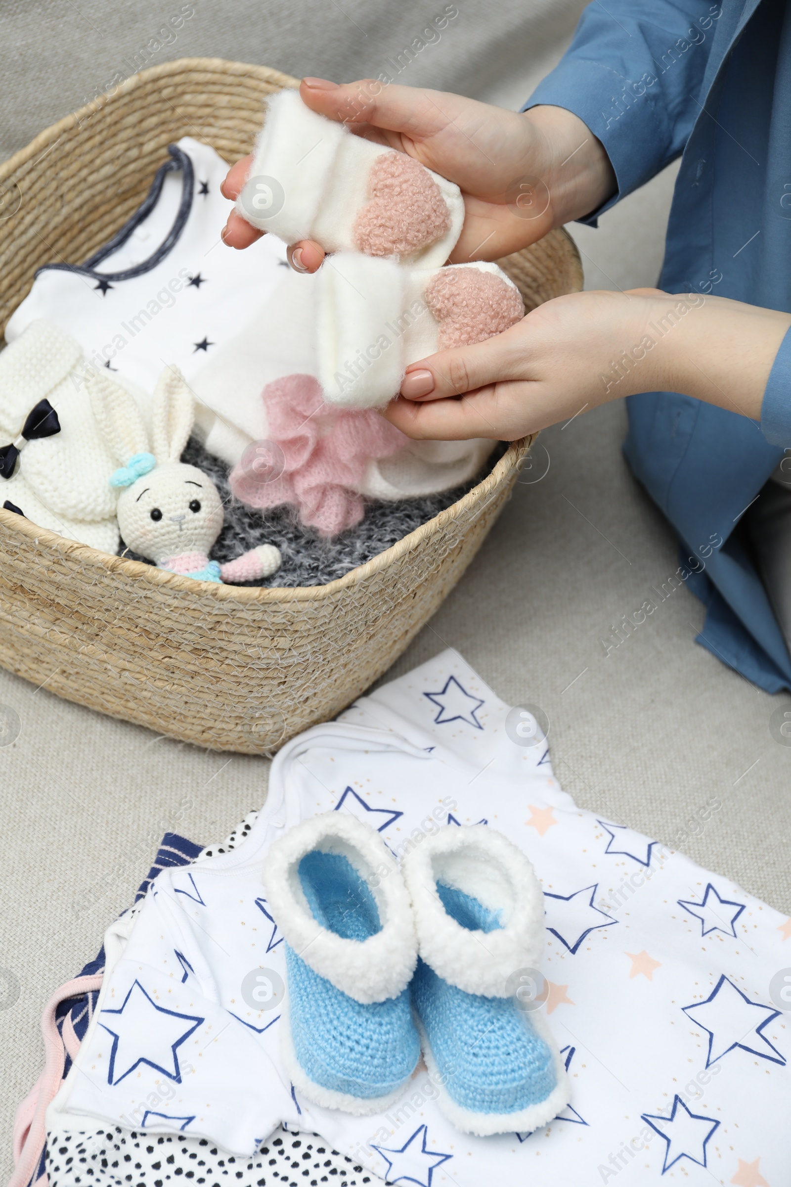 Photo of Woman with baby clothes on sofa at home, closeup